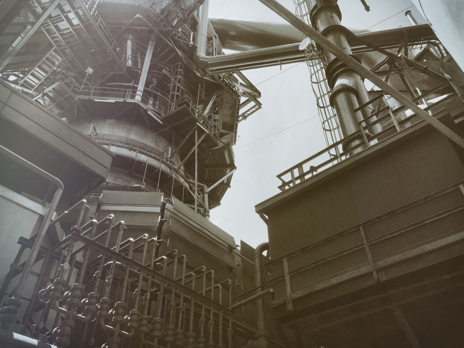 Low angle view of industrial steel structures and pipes, showcasing modern engineering.